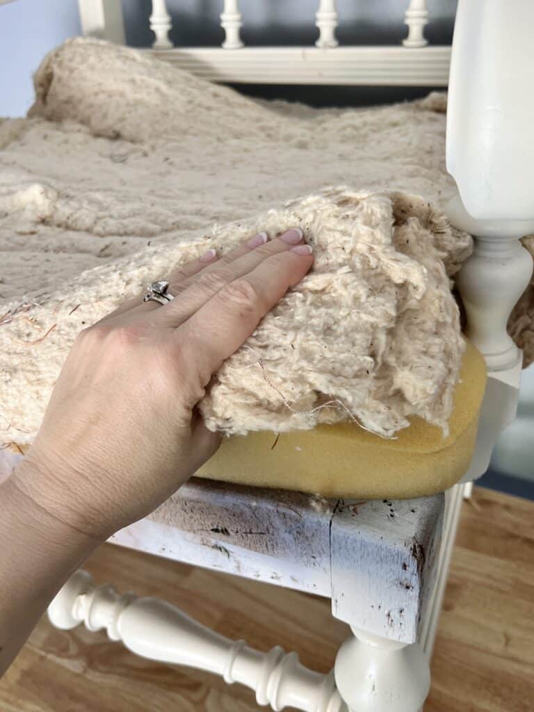 upholstery diy chair seat: Layering batting on top of a foam pad.