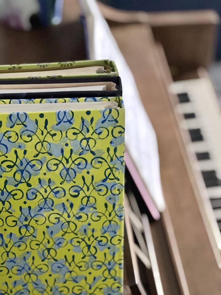 Music books standing on a piano.