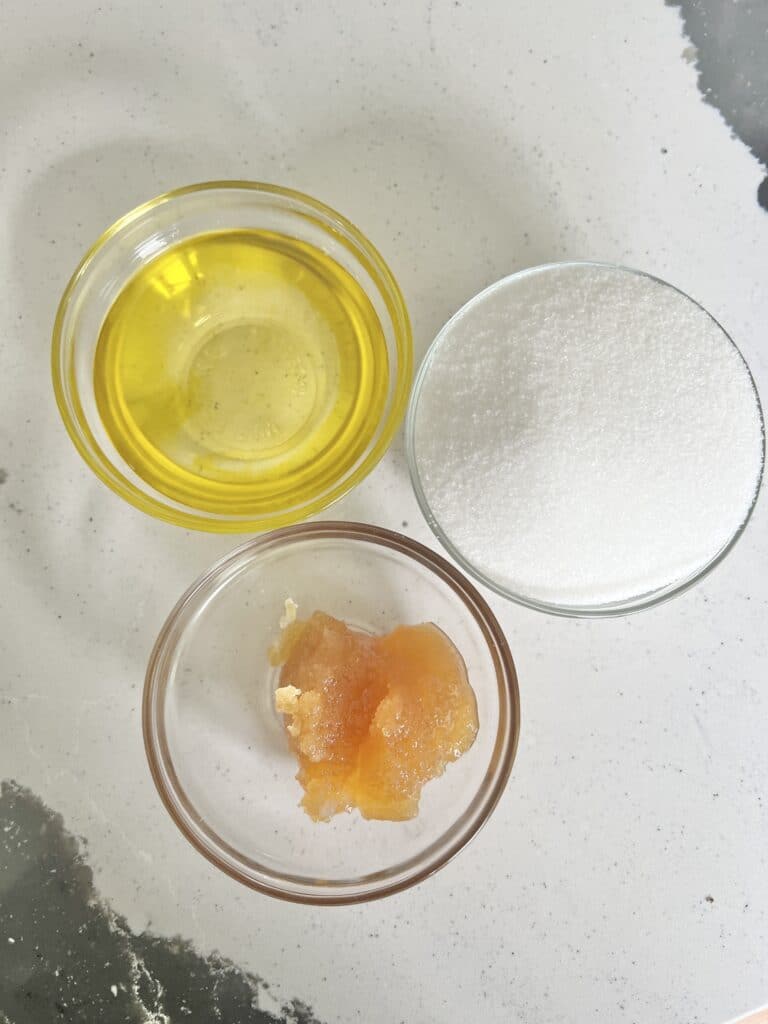 Benefits of lip scrub: Glass bowls of olive oil, sugar, and honey: the ingredients for aa lip scrub.