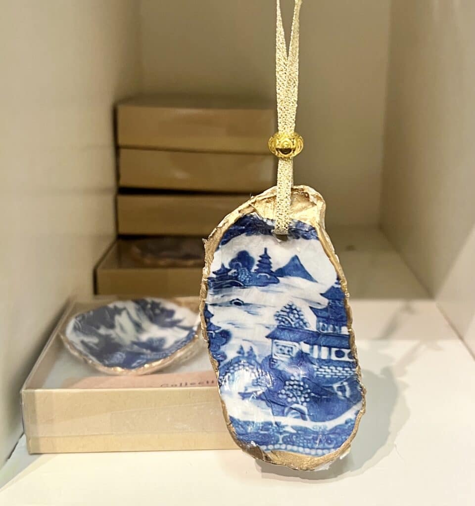 An oyster shell with a chinoiserie decoupage pattern on the front.