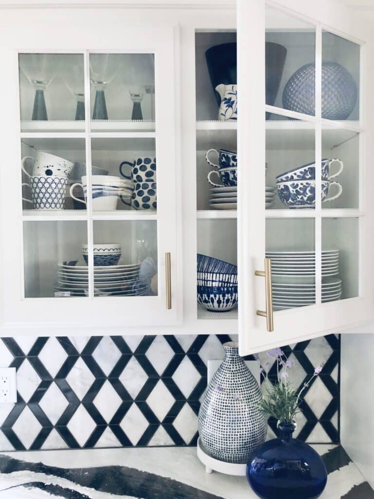 Glass front kitchen cabinets filled with blue and white dinnerware.