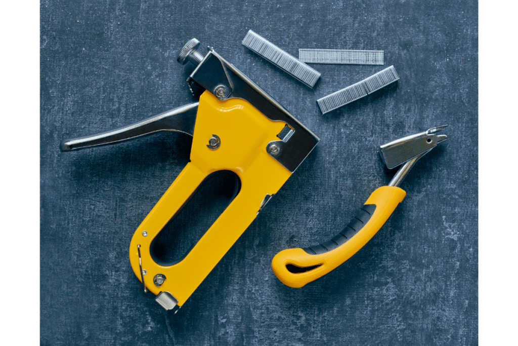 A staple puller and staple gun used for this upholstery chair project.