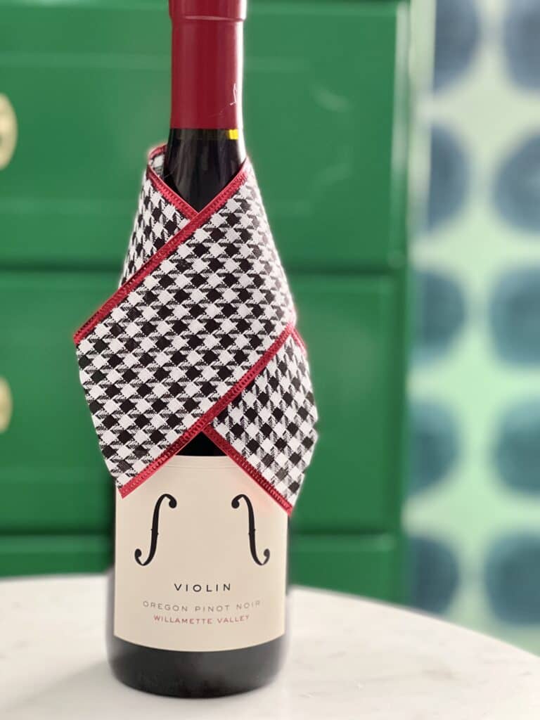 35 Thoughtful New Neighbor Housewarming Gift Ideas: A bottle of wine with a fabric ribbon "collar"