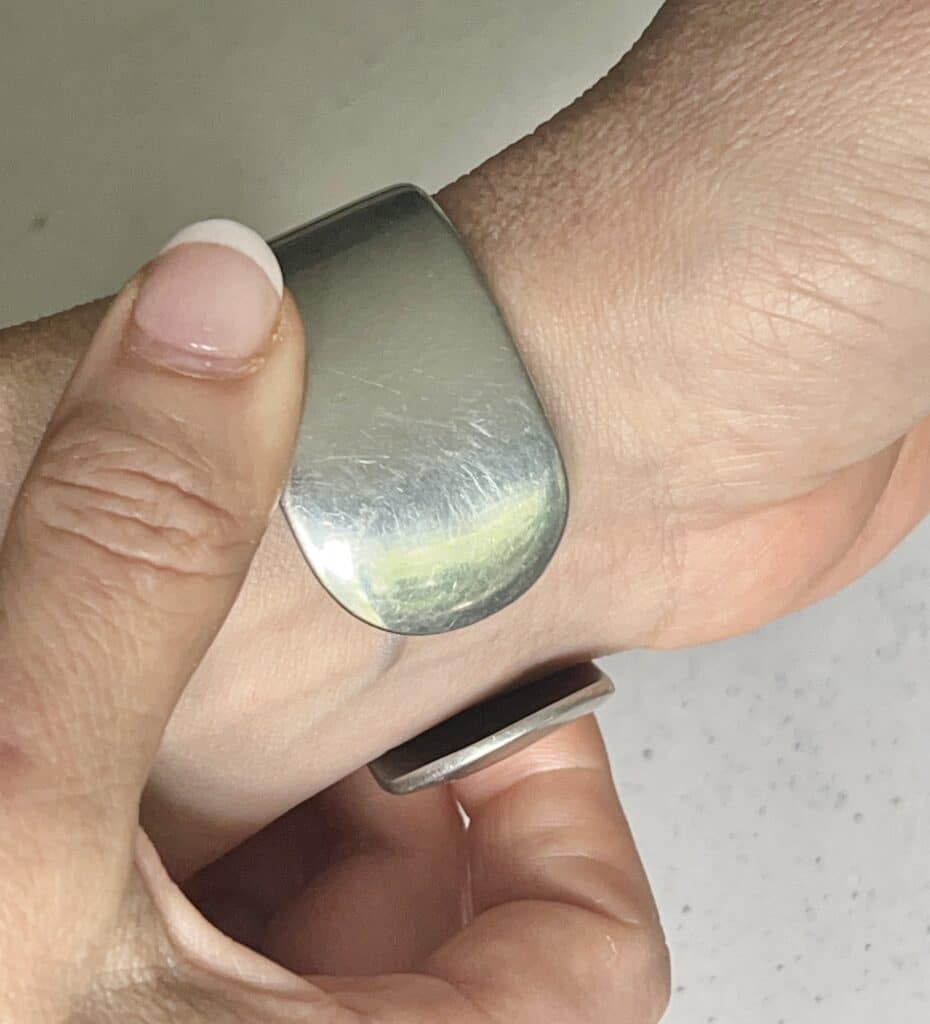Sliding a cuff bracelet onto the wrist.