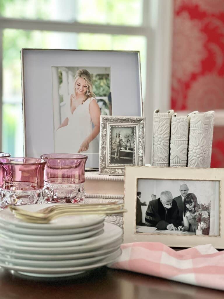everyday table centerpiece ideas: Stacked books on a dinner table with family photos displayed on and aaround the books.