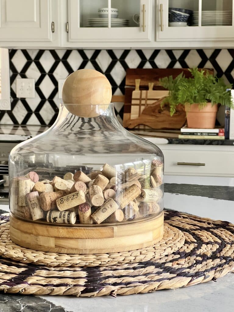everyday table centerpiece ideas; Used corks filling a glass terrarium and displayed on a dining space in the kitchen.
