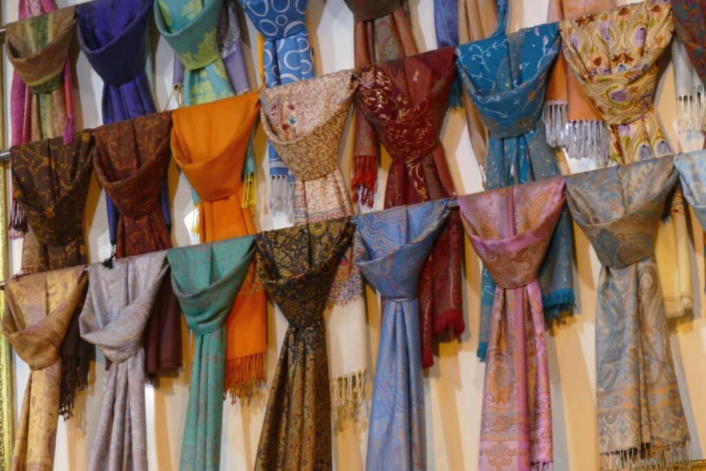 Multi-colored silk scarves hanging on a wall.