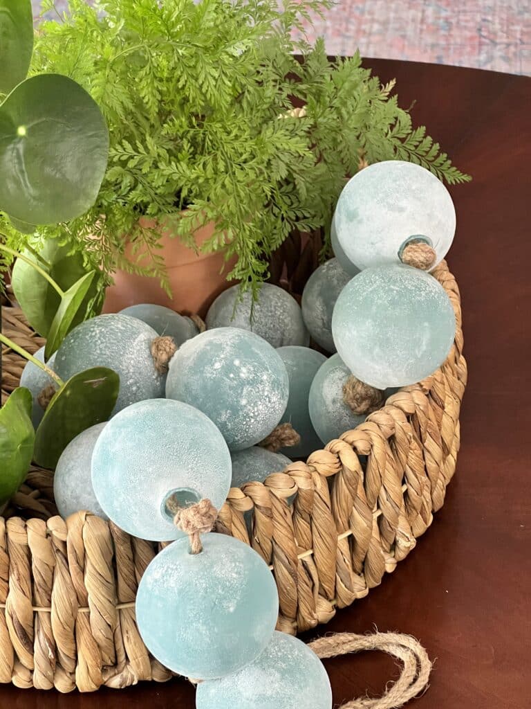 How to decorate with bead garland: Jumbo glass bead garland styled in a rattan basket.