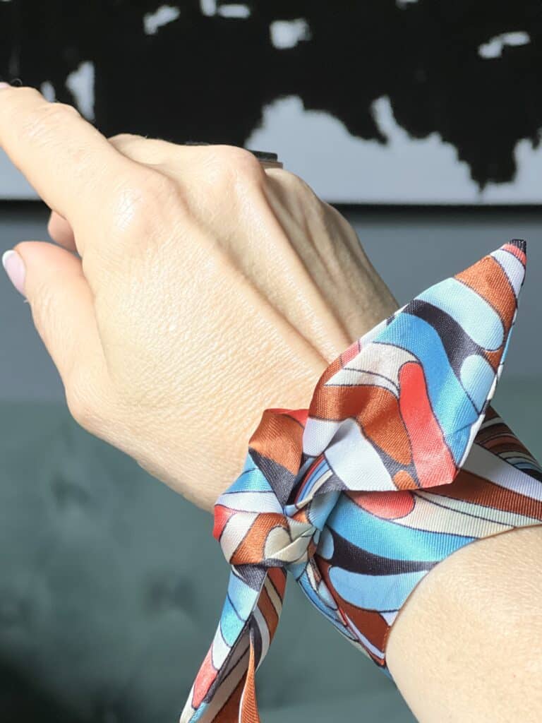 how to tie purse scarf: a skinny scarf tied to a wrist as a bracelet.