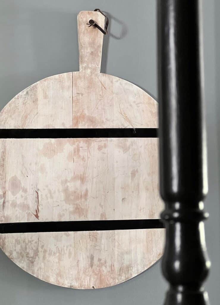 a black and white wood cutting board hanging on a wall.