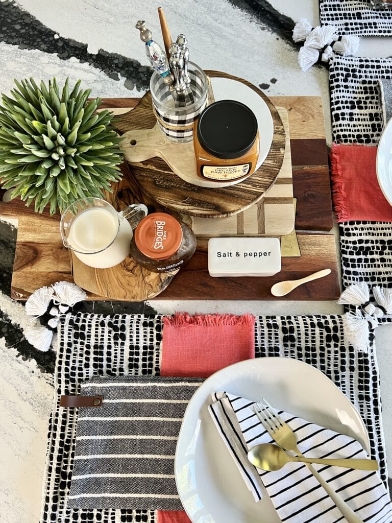 kitchen fall decor ideas: Stacked wooden cutting board placed on the center of a kitchen island as a centerpiece for breakfast.