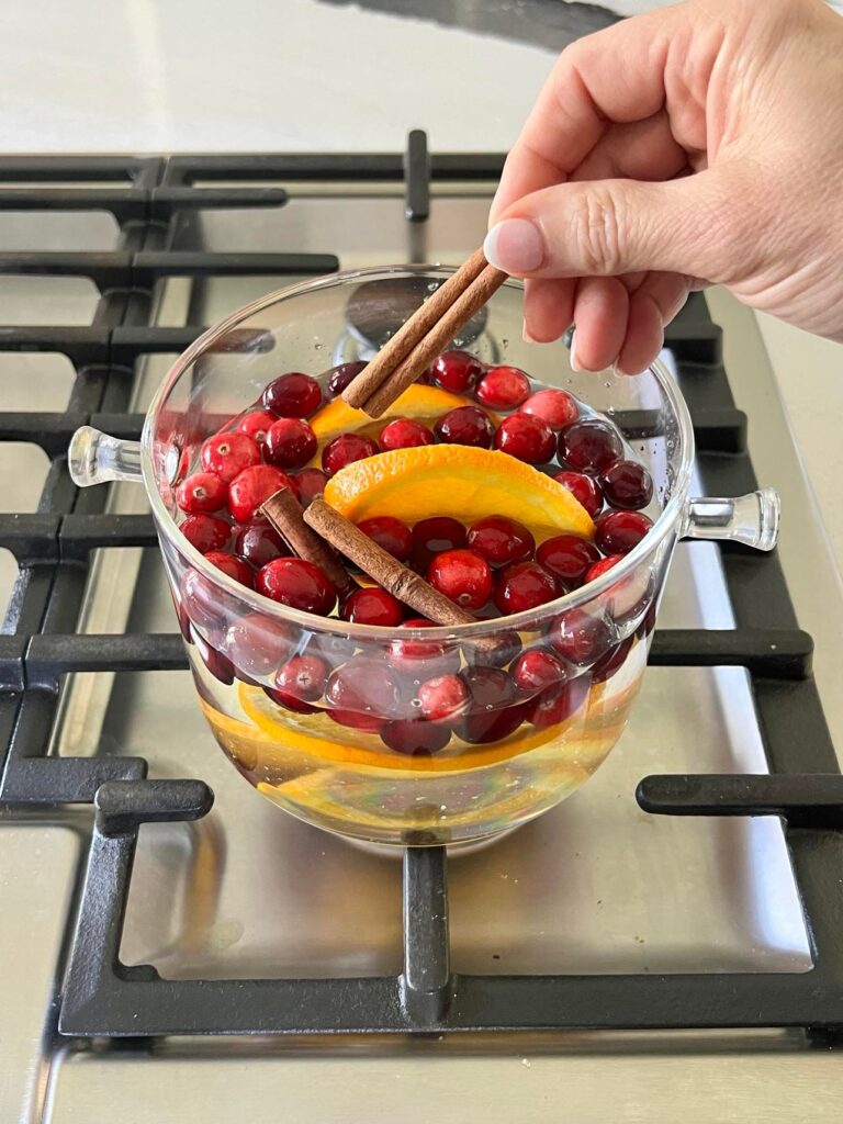 Adding cinnamon sticks to simmer pot recipes.