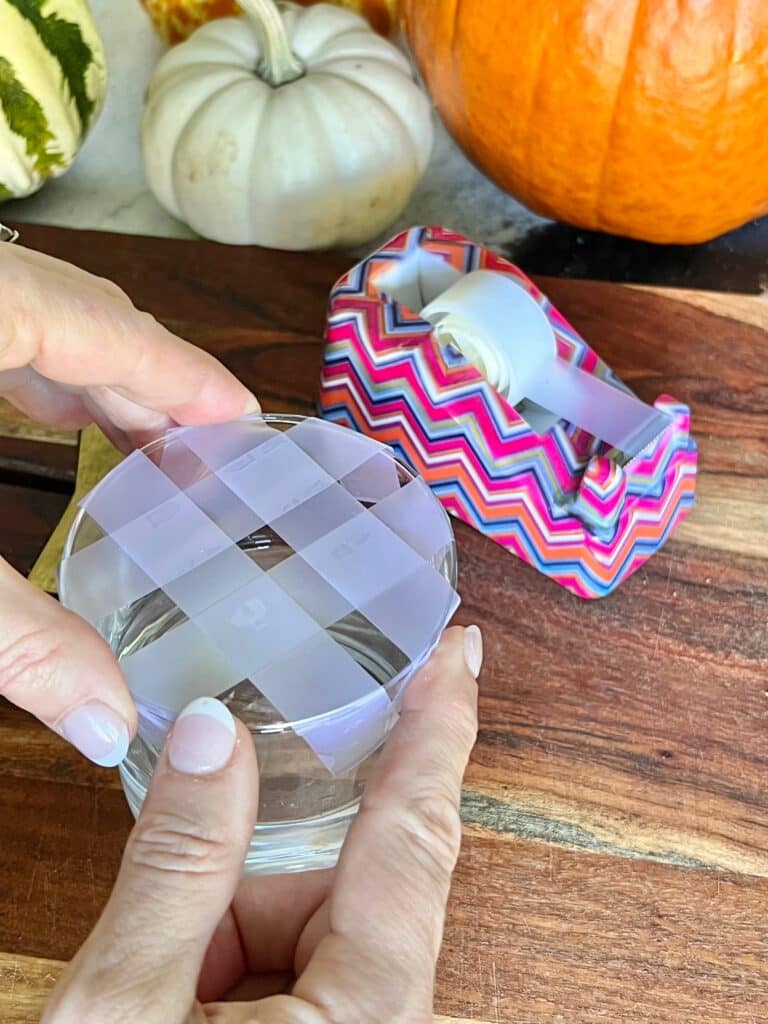 Creating a cellophane tape "frog" for the vase of a pumpkin floral vase arrangement.