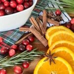 Ingredients for a Christmas Simmer Pot that include cranberries, orange slices, cinnamon sticks, and star anise.