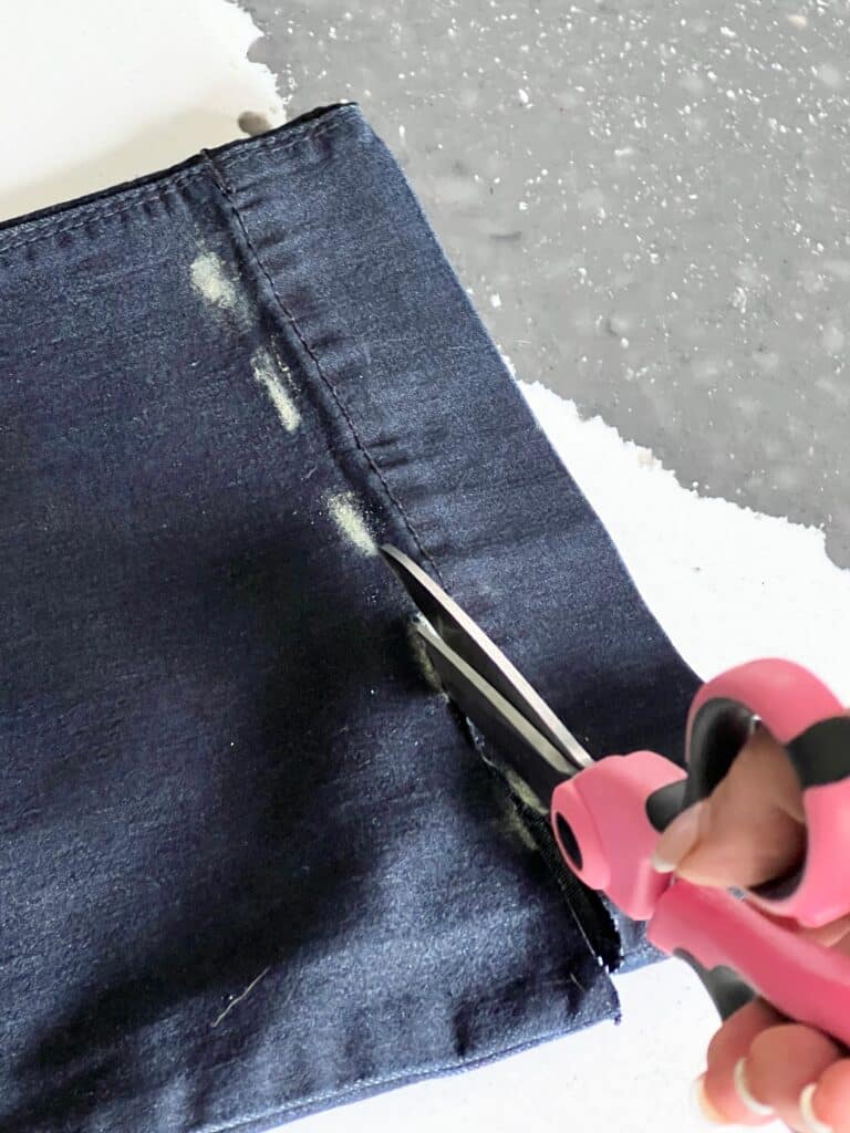 how to fray jeans: Cutting off the hem of aa pair of jeans.