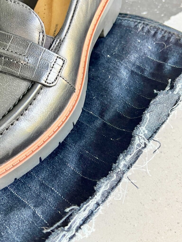 A frayed hem on a pair of jeans.