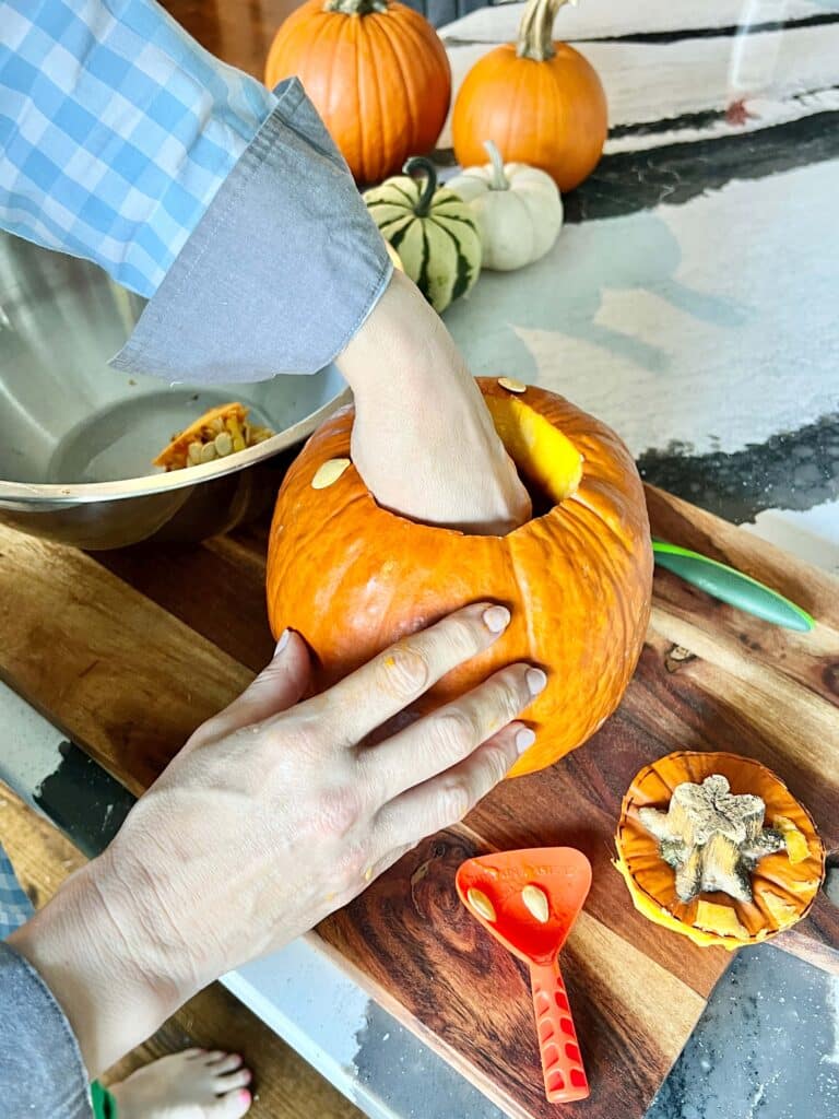 Digging out seeds from a pumpkin.