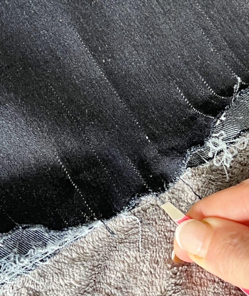 how to fray jeans: Pulling vertical threads using tweezers.