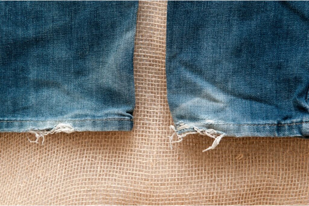 The frayed hem of denim jeans.
