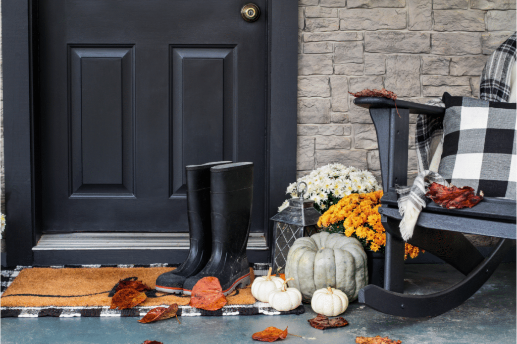 Pumpkins sitting beside a rocking chair.