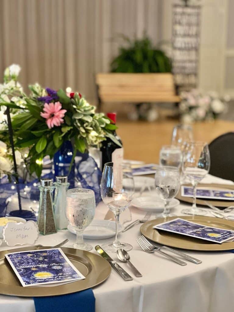 A gala table setting overlooking a park bench.