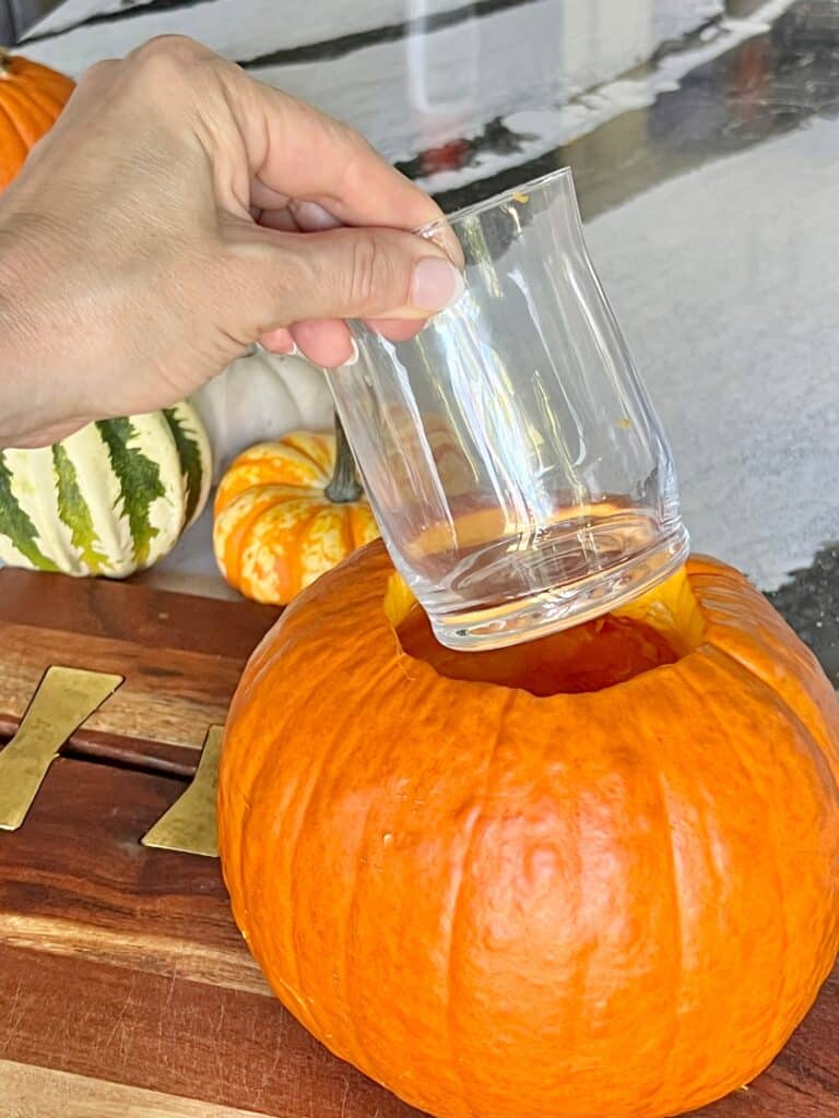 Inserting a glass vase to create pumpkin floral arrangements.