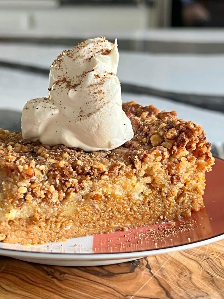 recipe for pumpkin pie crunch cake: served with whipped topping aan nutmeg.