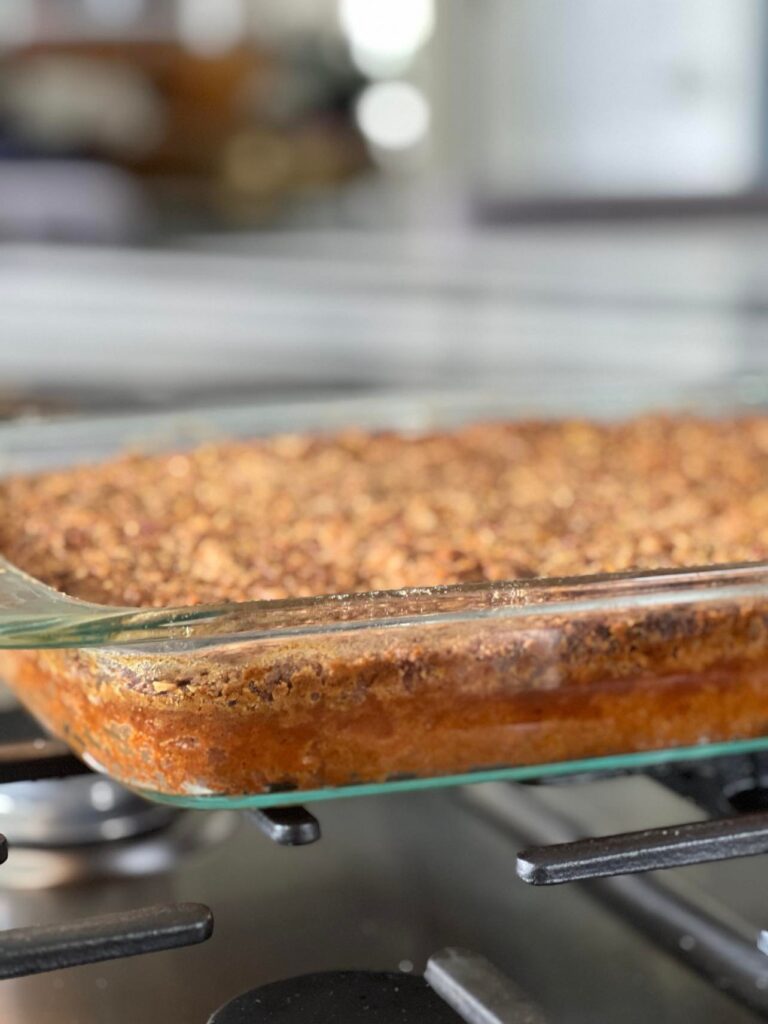 a pumpkin pie crunch cake cooling on a cooktop.