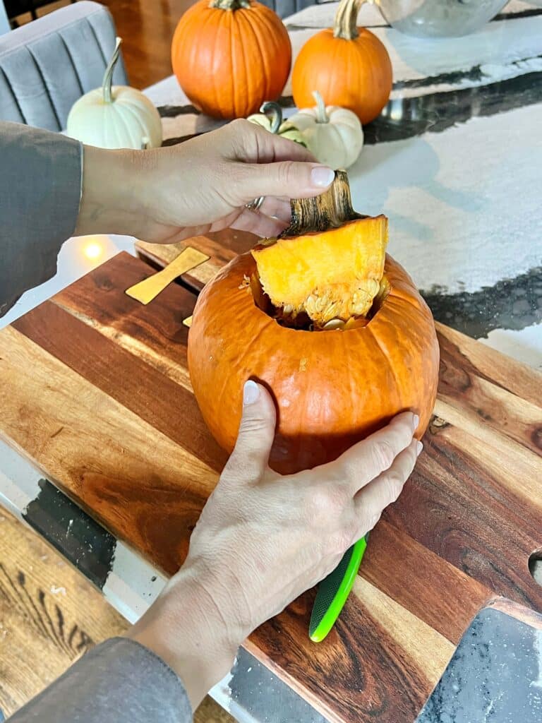 Removing the lid from a pumpkin.