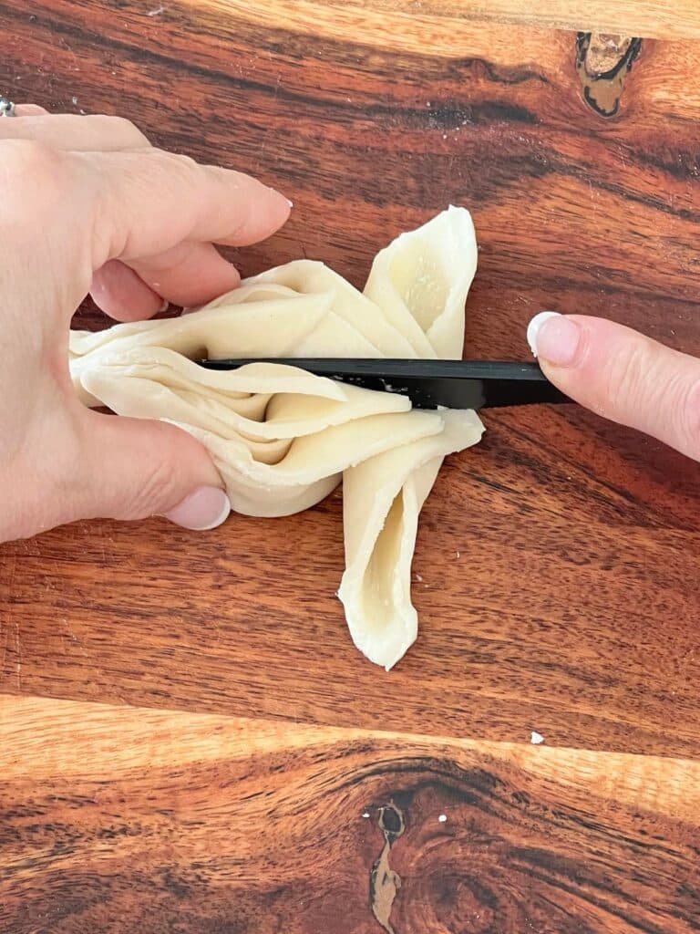 fall cookie recipe: Using a plastic knife to hold tthe pastry in place as the leaves are formed.