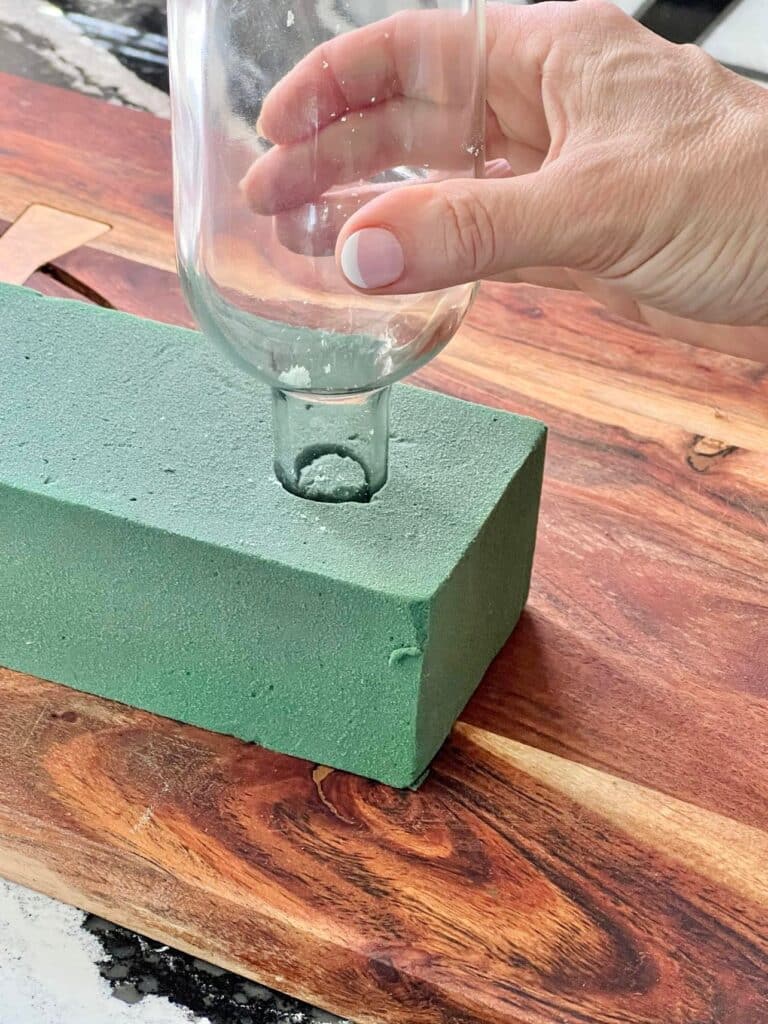 Imprinting floral foam with the top of a wine bottle.