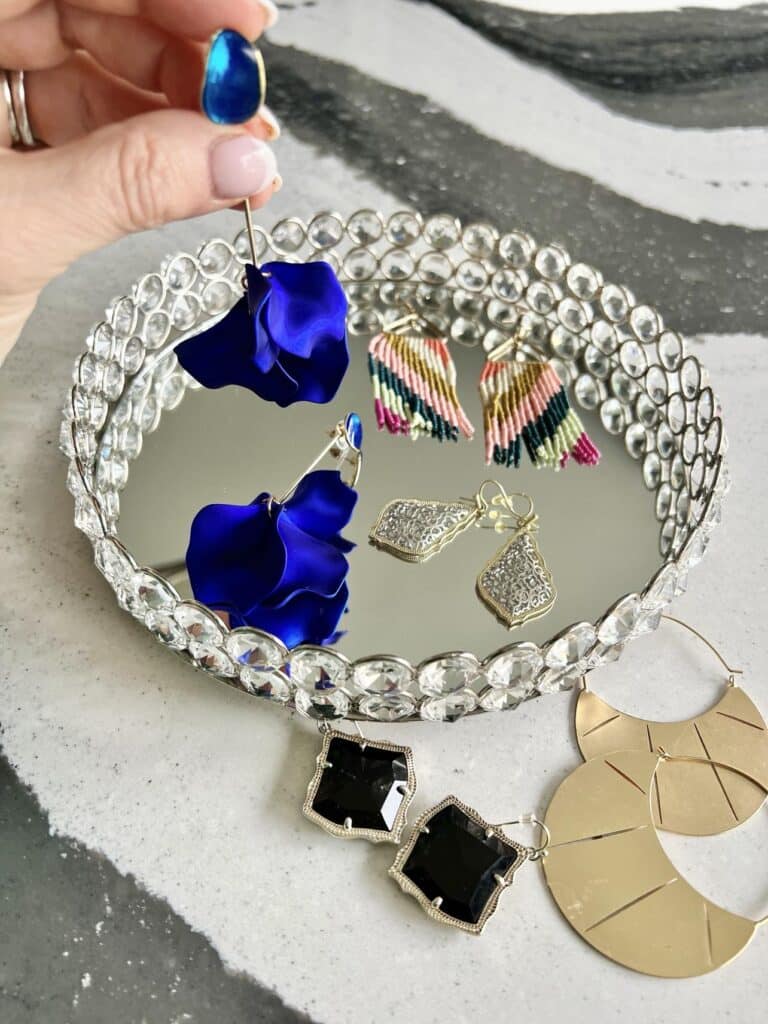 A glass tray full of various pierced earrings.