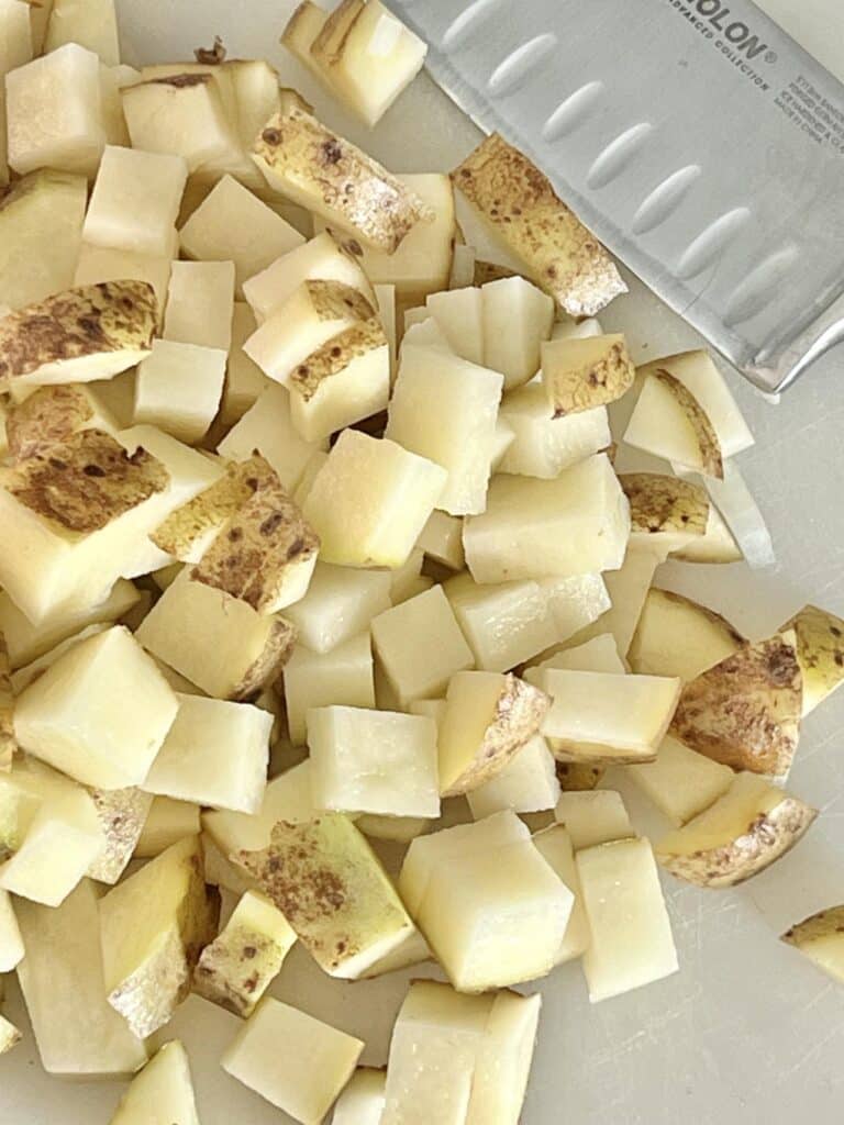 Cubed potatoes on a cutting board.