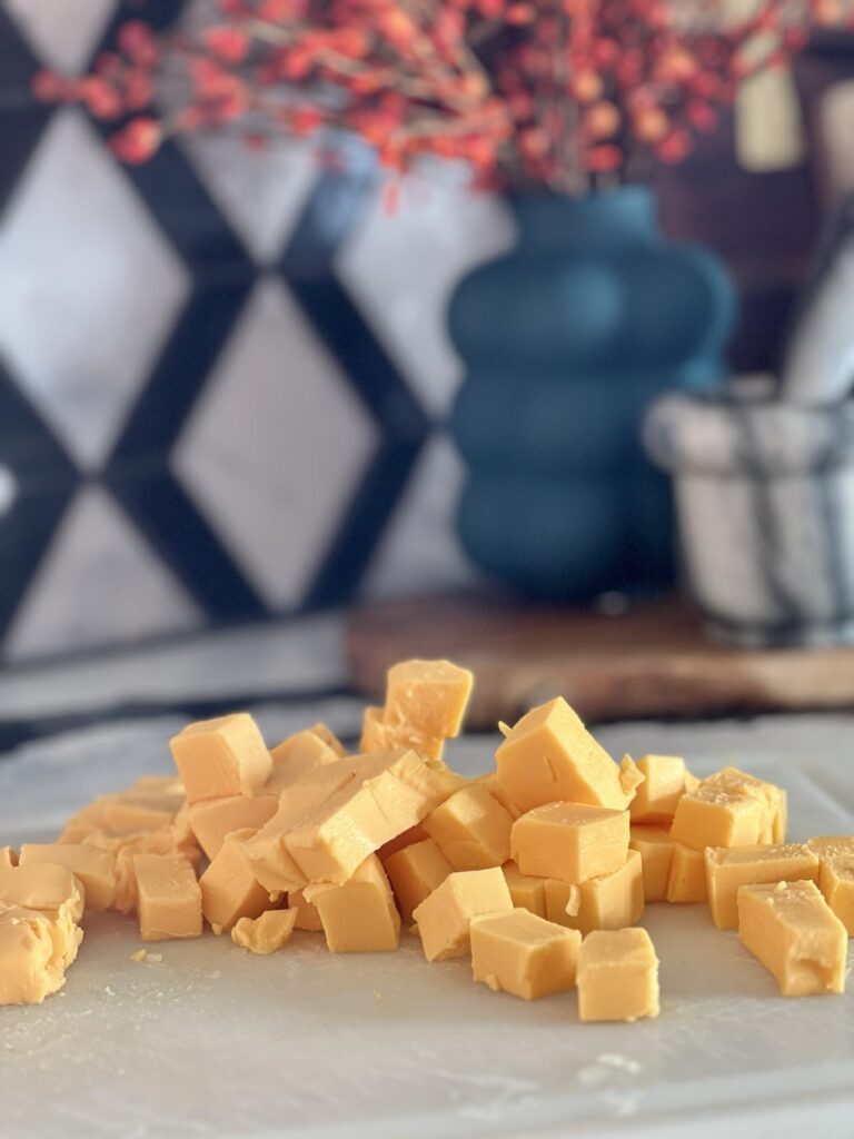 Cubed Velveeta cheese on a cutting board.