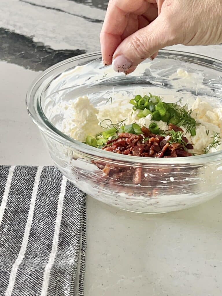 Combining the cream cheese mixture for this holiday cheese ball recipe.