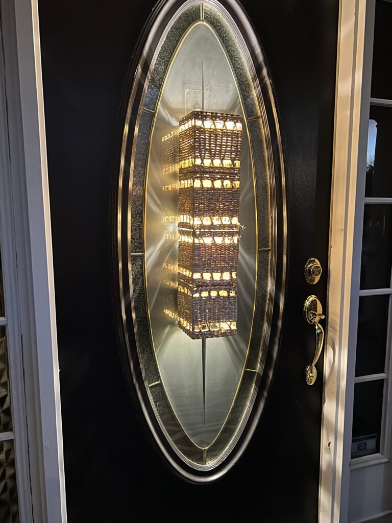 An illuminated wireless DIY glass door insert light sconce at night.