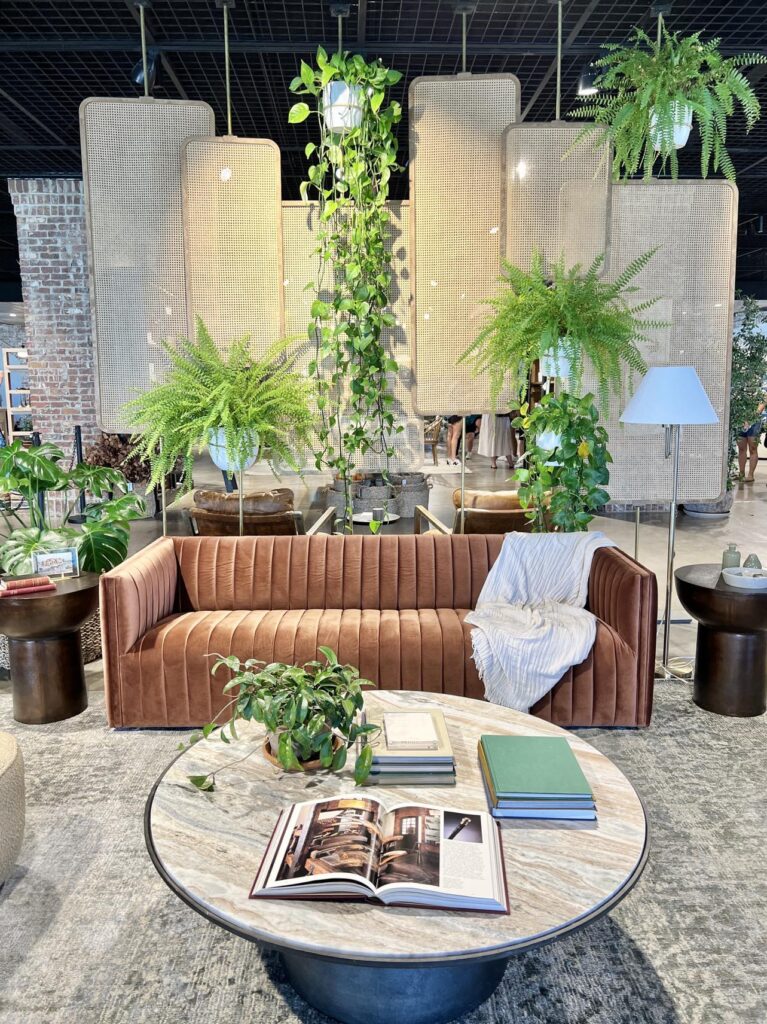 a sofa in front of a rattan wall installaation.