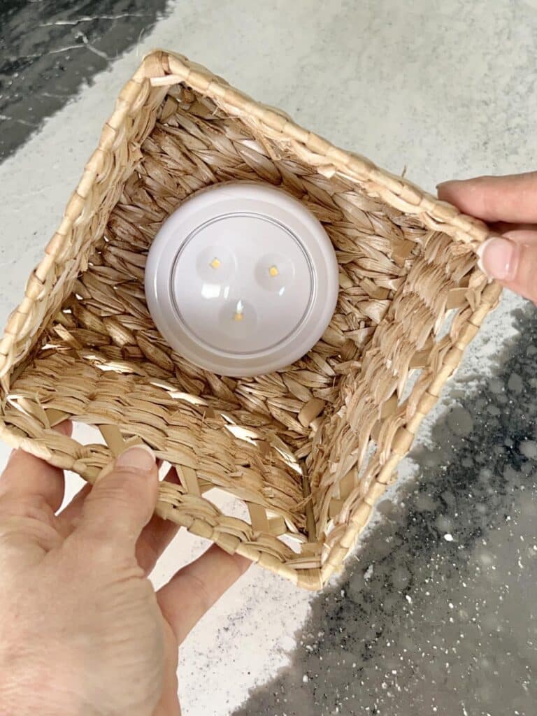 A puck light glued to the inside of a rattan tissue box.
