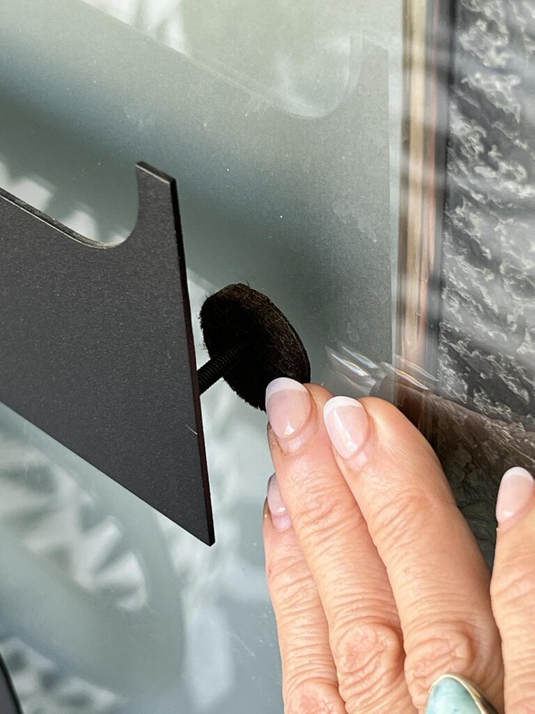 Using a felt pad to cushion diy glass door insert decor.