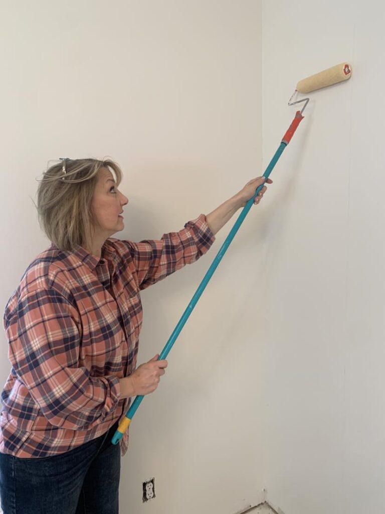How to hang a wallpaper mural - using a roller brush to apply wallpaper adhesive directly to the wall.