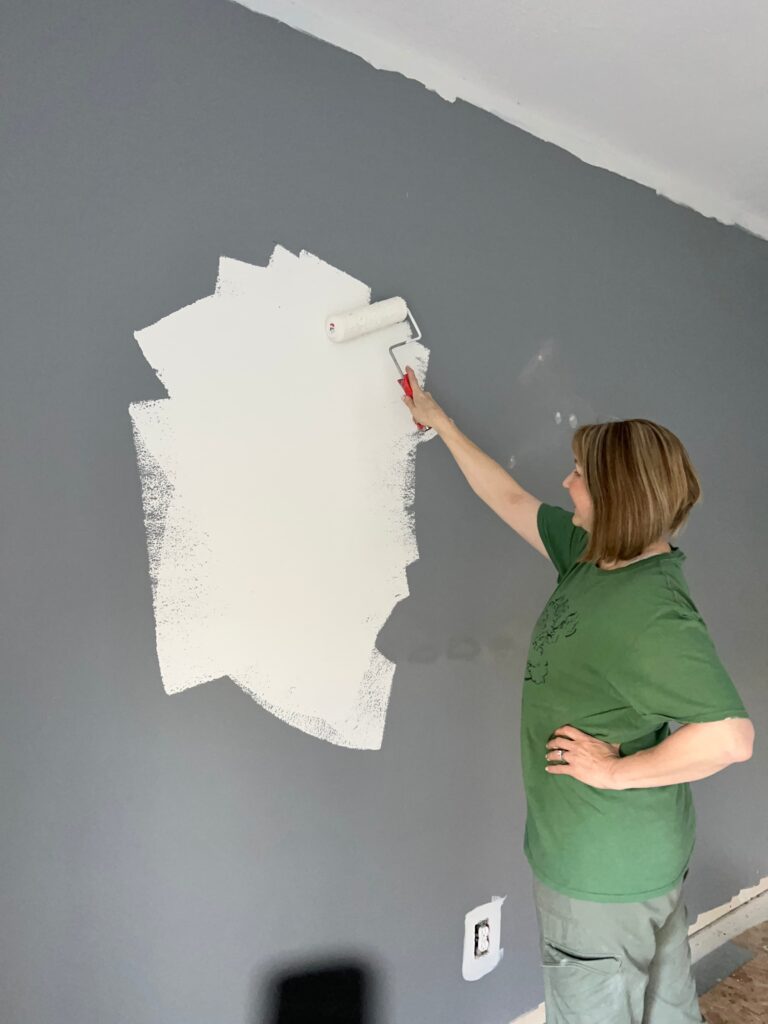 Painting a wall in preparation for hanging wallpaper