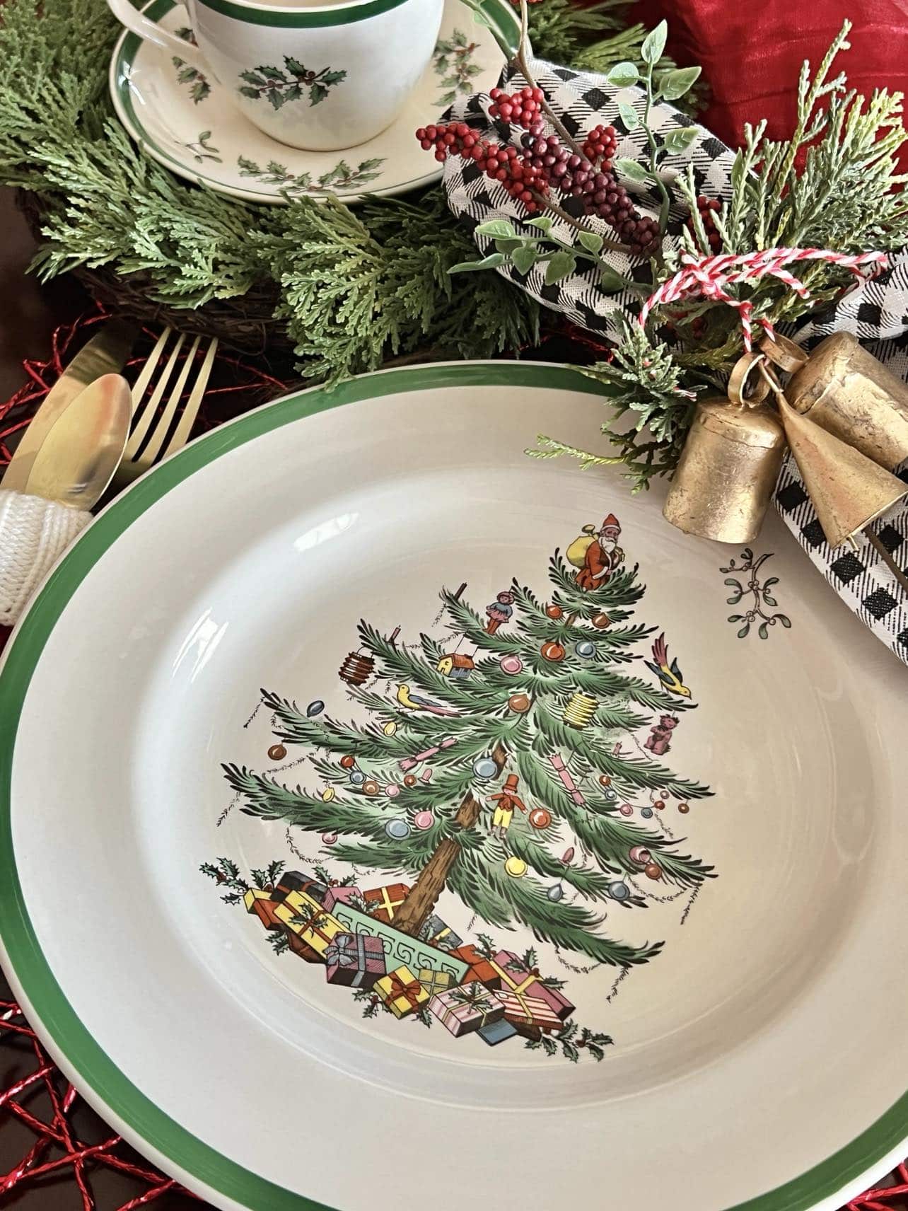 https://www.sonatahomedesign.com/wp-content/uploads/2023/11/Spode-Christmas-dishes-in-a-Christmas-setting-with-bells-Sonata-Home-Design.jpg