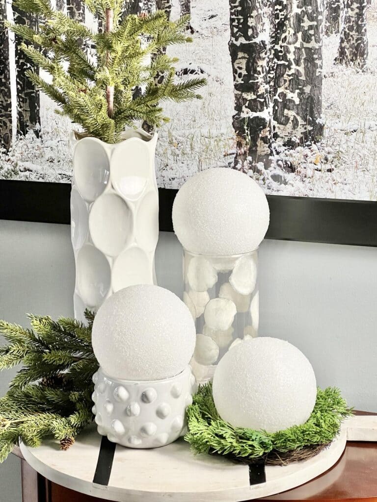 diy faux snowballs sitting in front of winter themed wall art.