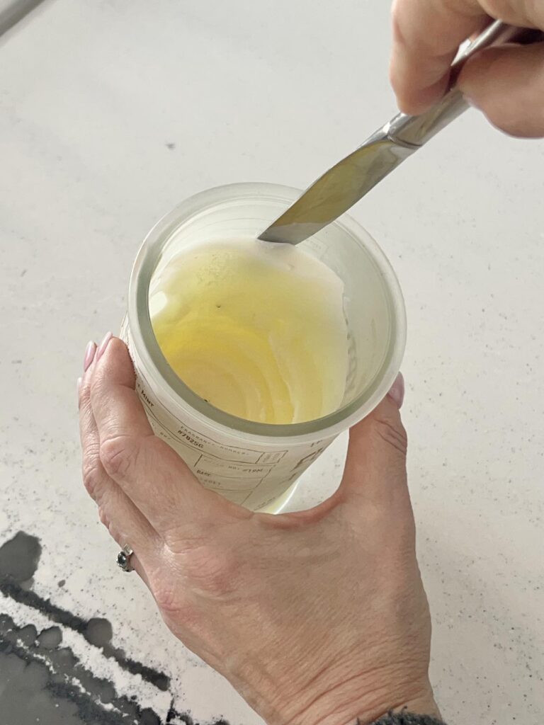 Use a butter knife to pry the frozen wax from the candle jar in order to clean it.