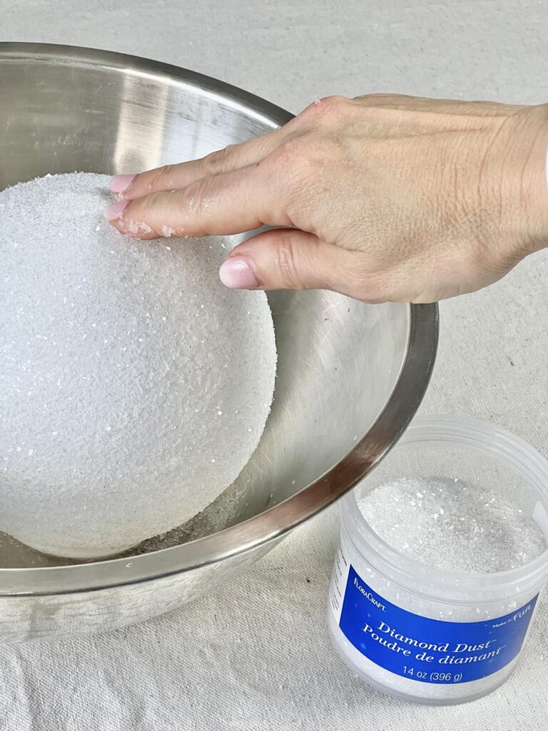 Pressing Diamond Dust onto a glass globe.