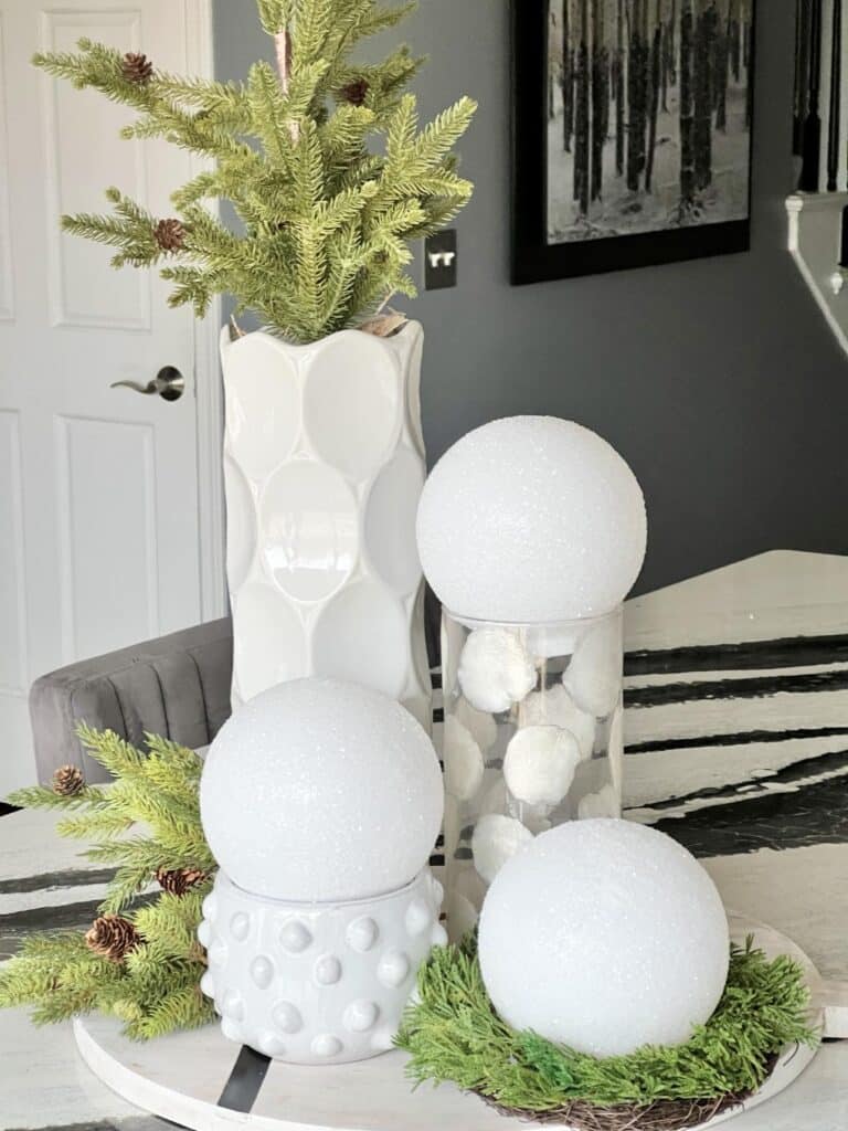 diy faux snowballs displayed on top of glass vases.