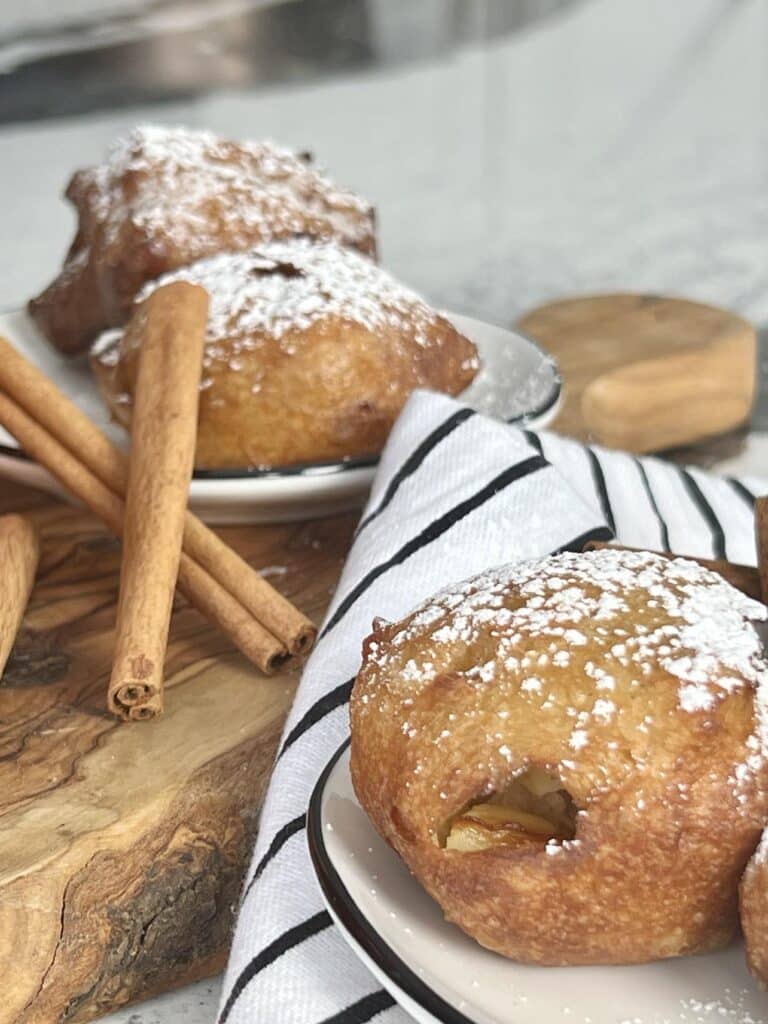 An apple beignet and cinnamon sticks.