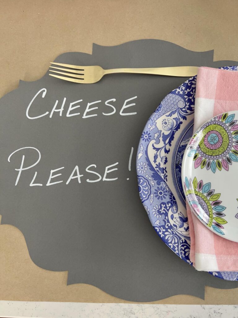 "Cheese please" written on aDIY paper placemat to decorate a Valentine table.