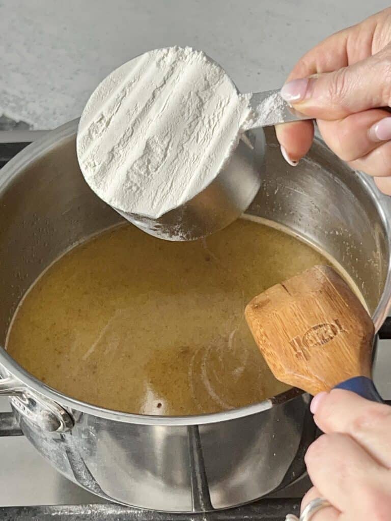 Pouring flour into the beignet batter.