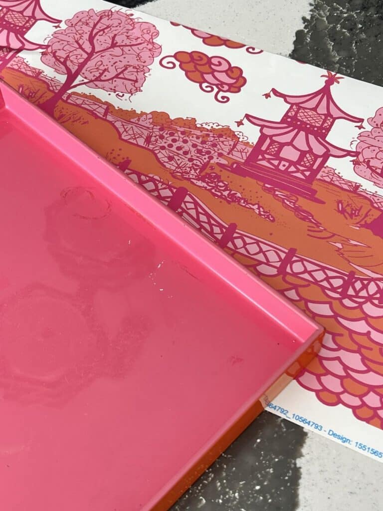 A pink tray and a piece of wallpaper.